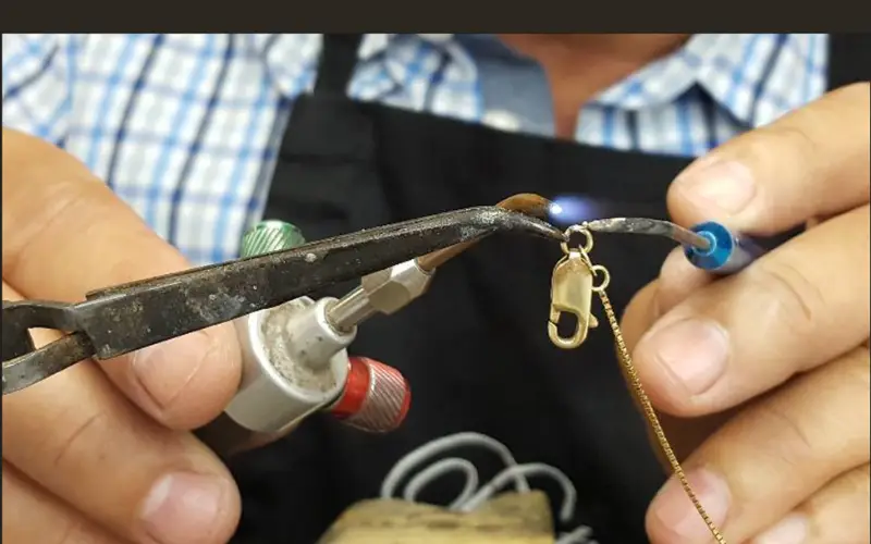 necklace clasp repair by professional jeweler using precision tools