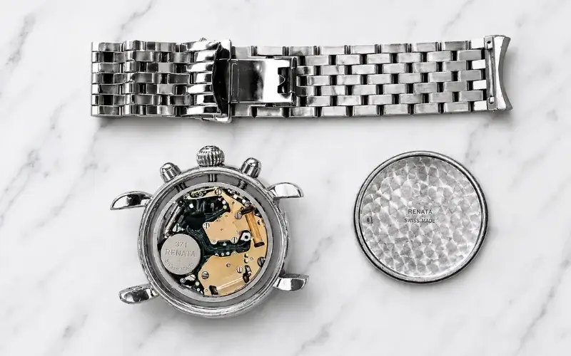 watch repair showing internal movement components and bracelet requiring professional service